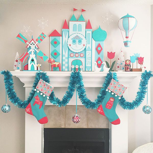 a fireplace decorated for christmas with stockings and decorations on the mantel above it is a castle