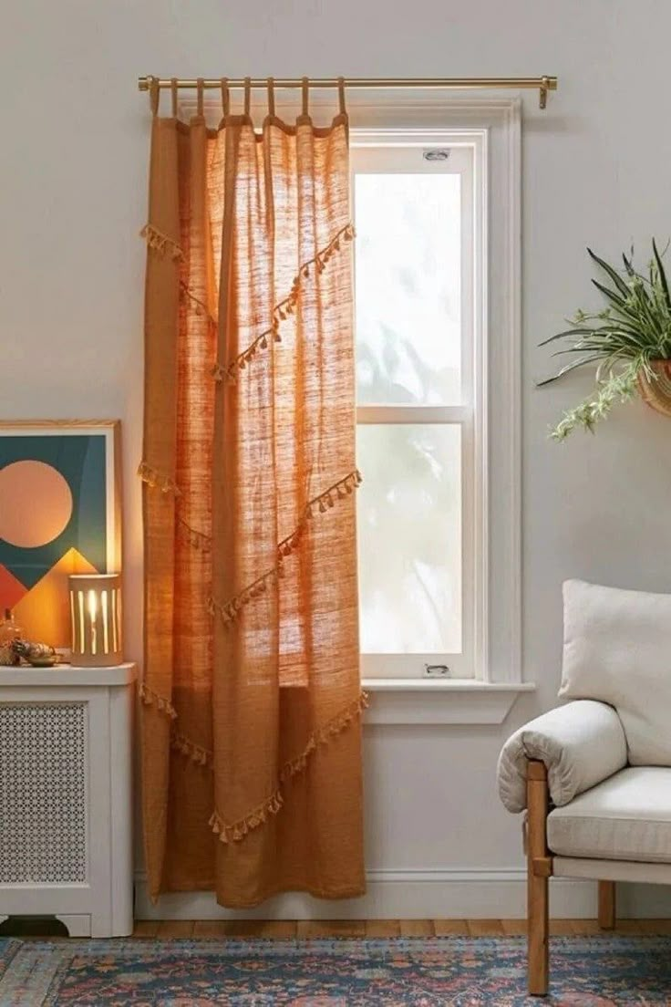 a living room with a chair, window and potted plant on the side of the wall