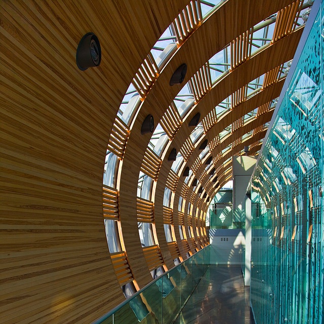 the inside of a building with wood and glass covering it's walls, along with an escalator