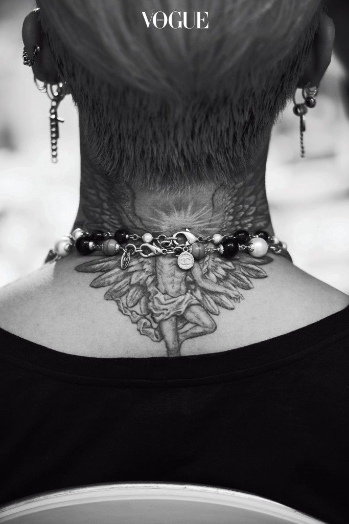 the back of a woman's neck with tattoos on it