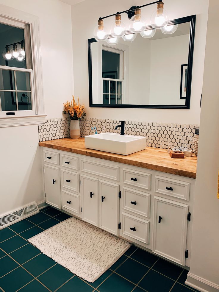 a bathroom with a sink, mirror and rug on the floor