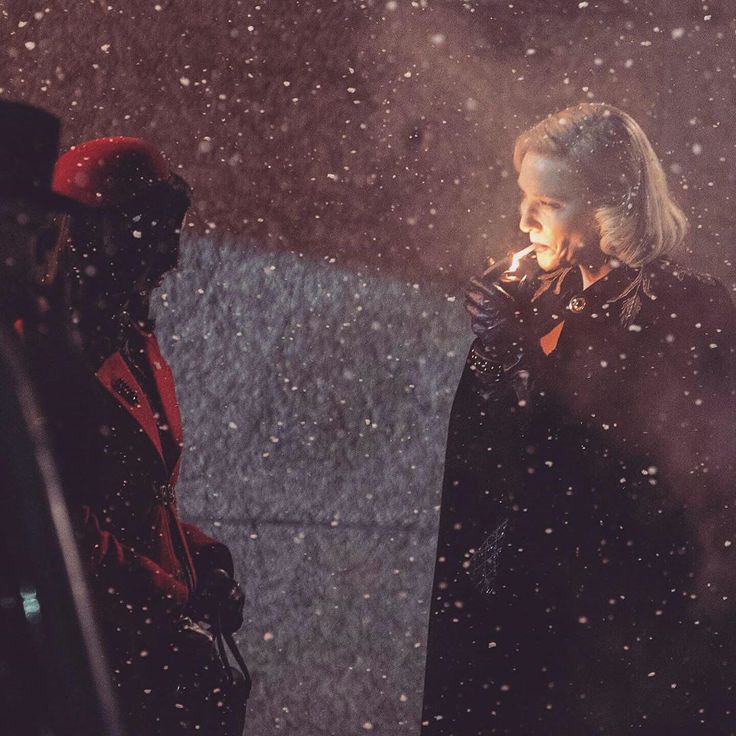 a woman standing next to a man in the snow