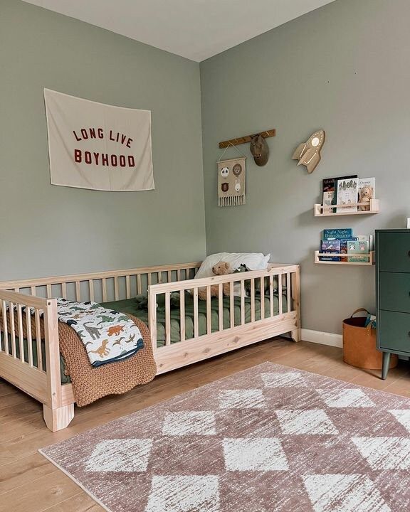 a baby's room with a crib, dresser and rug