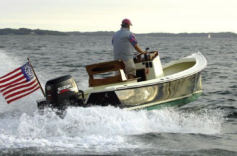 a man riding on the back of a boat in the ocean next to an american flag