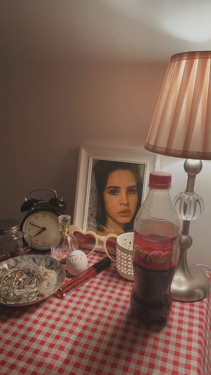 a table topped with a lamp next to a framed photo