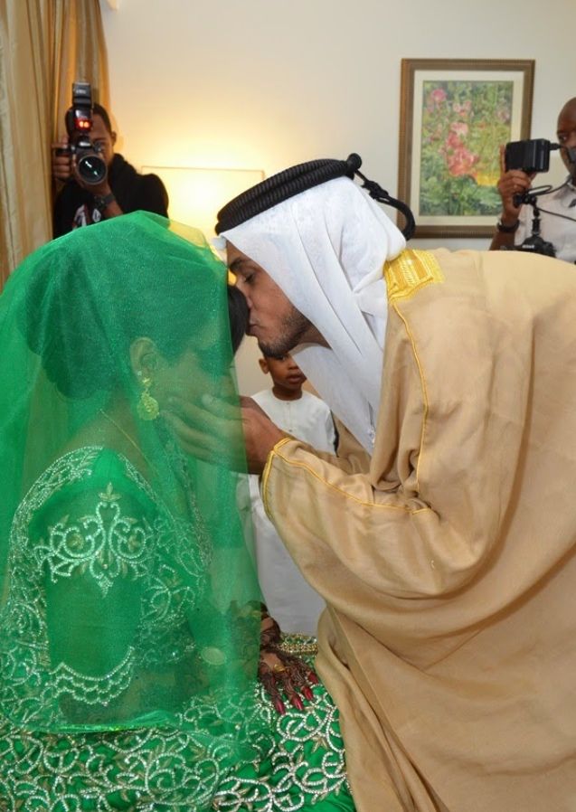 two men in traditional garb are touching each other's face with their hands