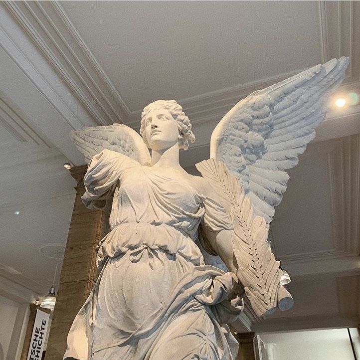 an angel statue is shown in the middle of a room with white walls and ceilings