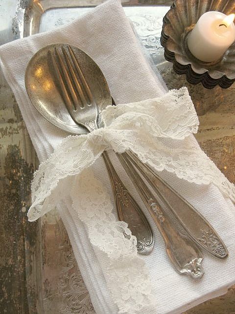 two silverware are sitting on top of a white napkin with a bow around it