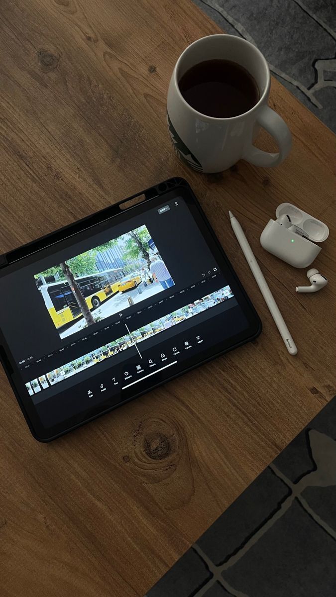 a tablet computer sitting on top of a wooden table next to a cup of coffee