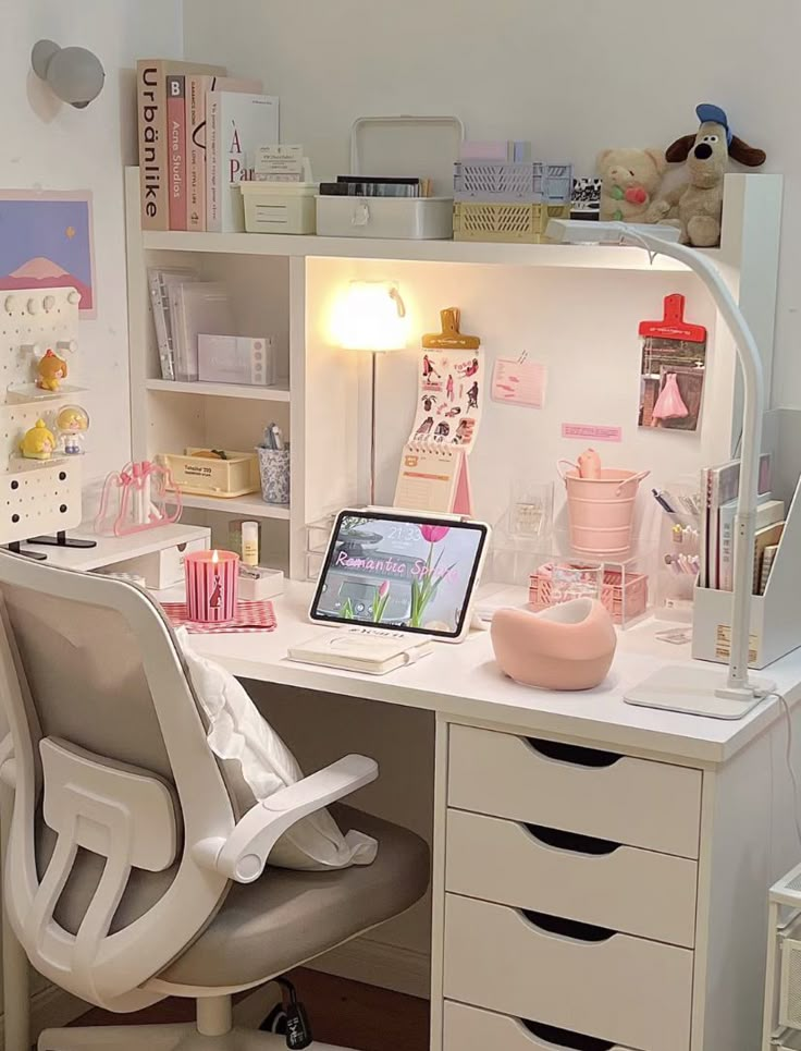 a white desk topped with a laptop computer sitting next to a drawer filled with lots of drawers