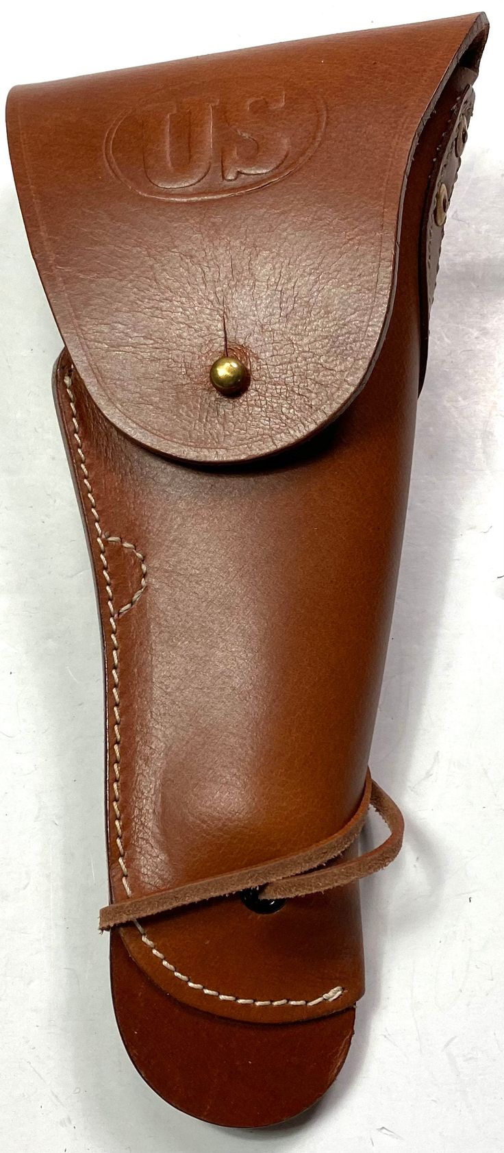 a brown leather case with a gold button on the top and bottom corner, sitting on a white surface