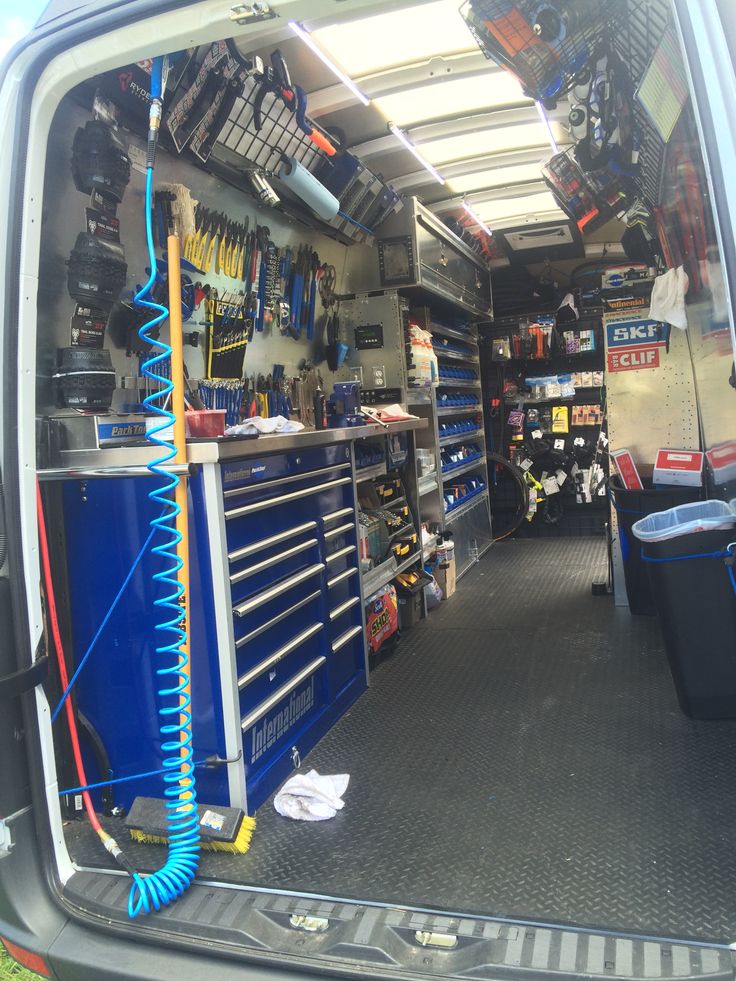 the inside of a vehicle with tools and equipment in it's storage area,