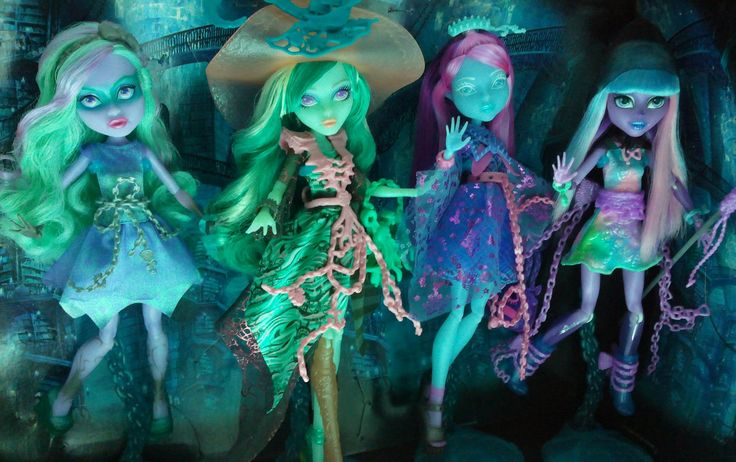 three dolls dressed up as witches in front of a dark room with green and blue lighting