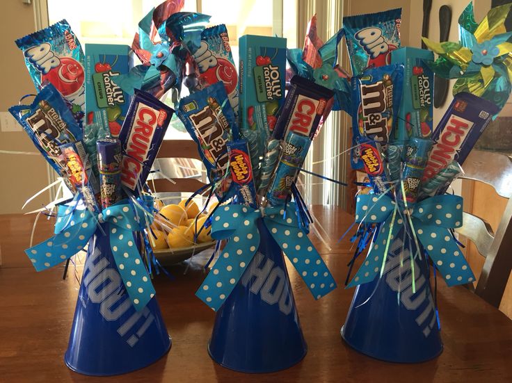 two blue vases filled with candy sitting on top of a wooden table