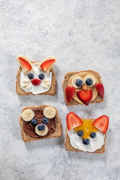 three slices of toast with fruit, cream and toppings on them in the shape of animals