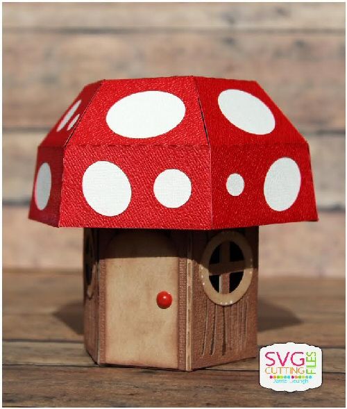 a small red and white mushroom house on top of a wooden table