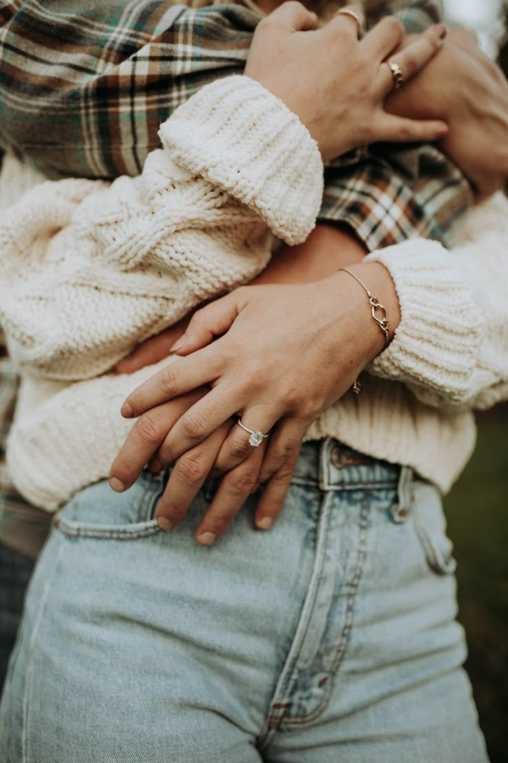 a close up of two people holding each other with their hands wrapped around one another