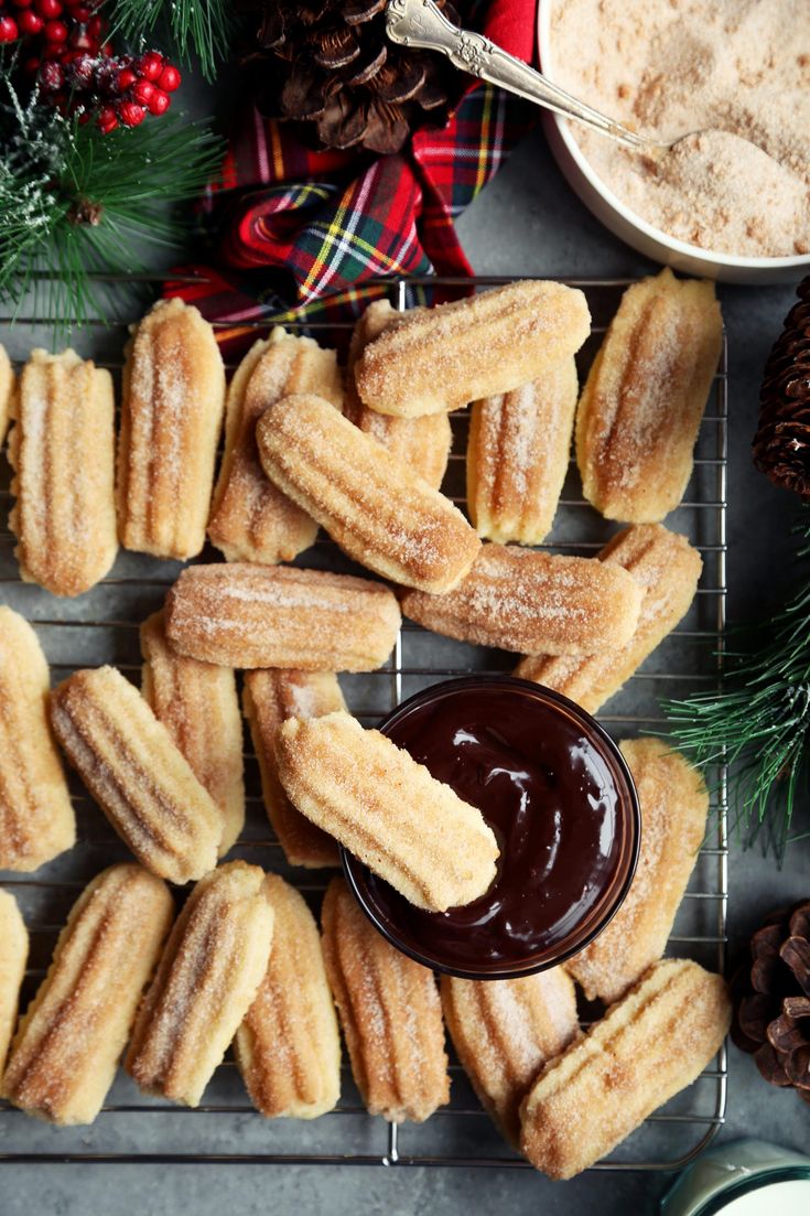 some sugary treats are on a cooling rack next to pine cones and other holiday decorations