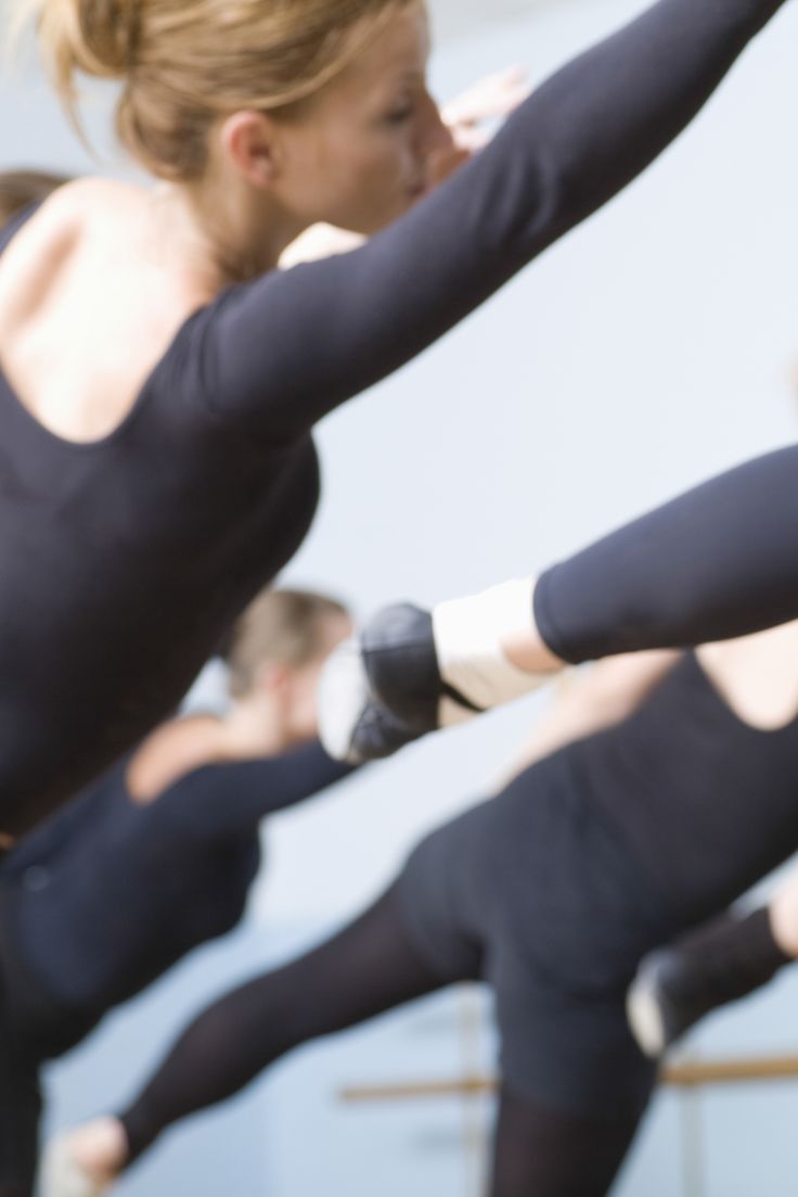 a group of women doing yoga poses with their hands in the air