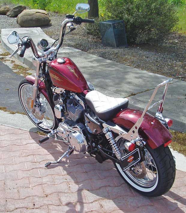 a red motorcycle parked next to a sidewalk