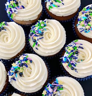 several cupcakes with white frosting and sprinkles