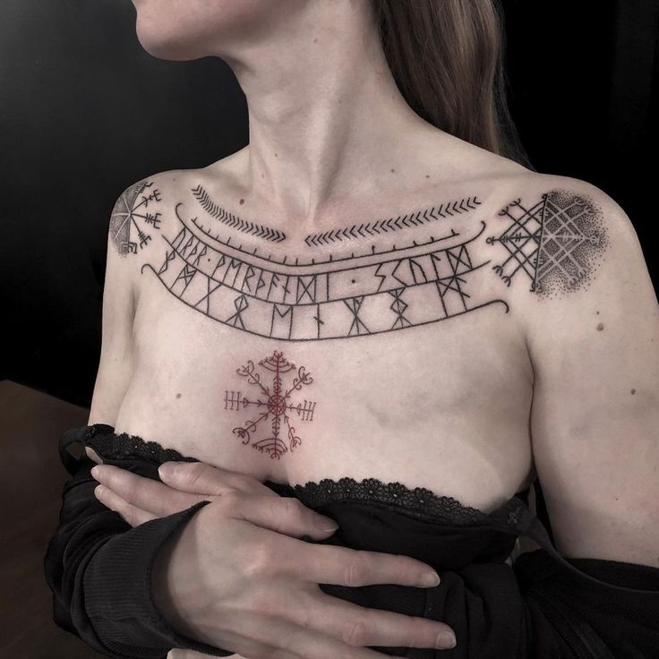 a woman with tattoos on her chest and arm