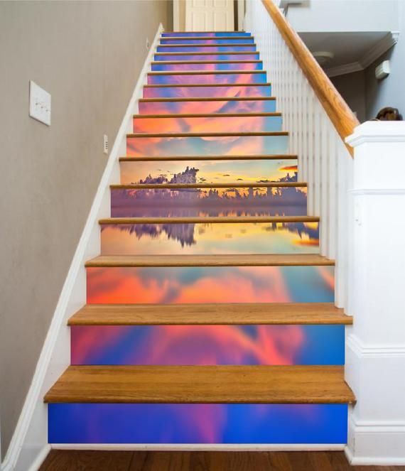 the stairs are painted with colorful clouds and sunsets in the sky, as well as water