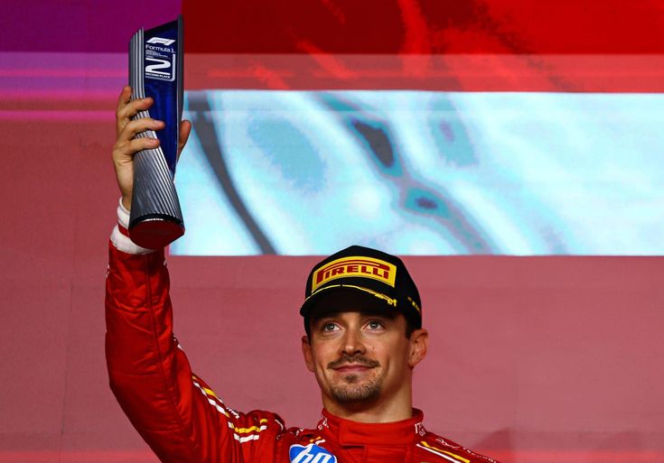 a man in a red uniform holding up a trophy