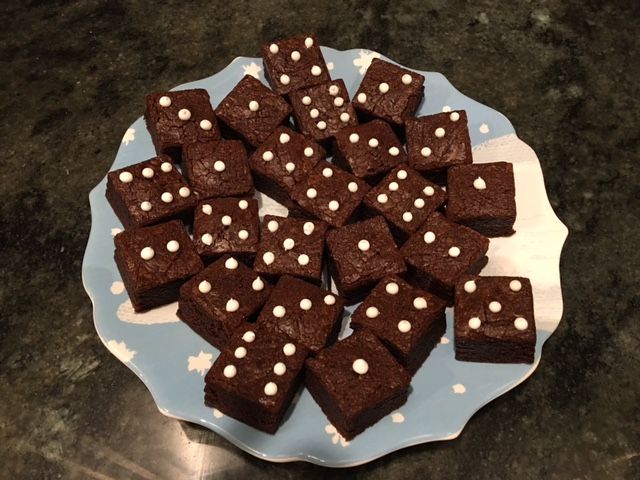 a blue plate topped with brownies covered in white polka dots