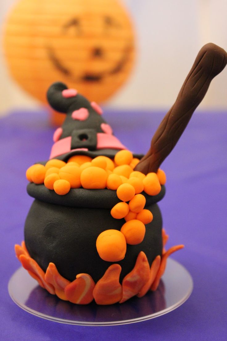 there is a cake that looks like a witch's caulder on the table