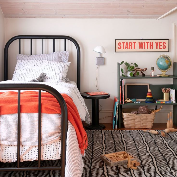 a bed room with a neatly made bed and a book shelf