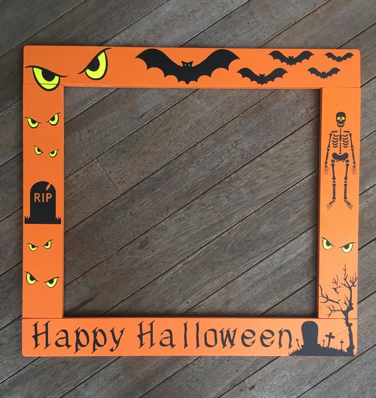 an orange halloween frame with a skeleton and pumpkins on the side, sitting on a wooden floor