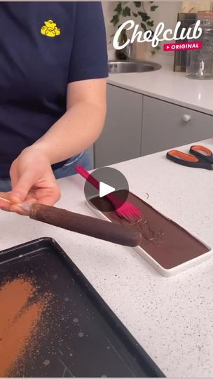 a person is spreading chocolate on top of a cookie sheet