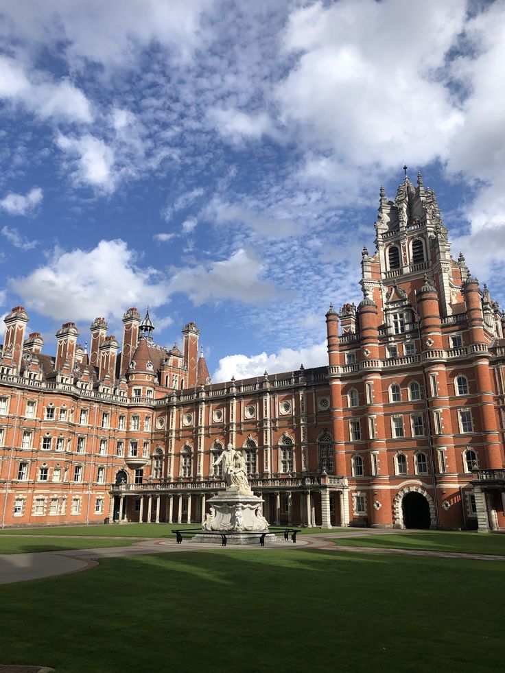 an old building with a statue in front of it on a sunny day and blue sky