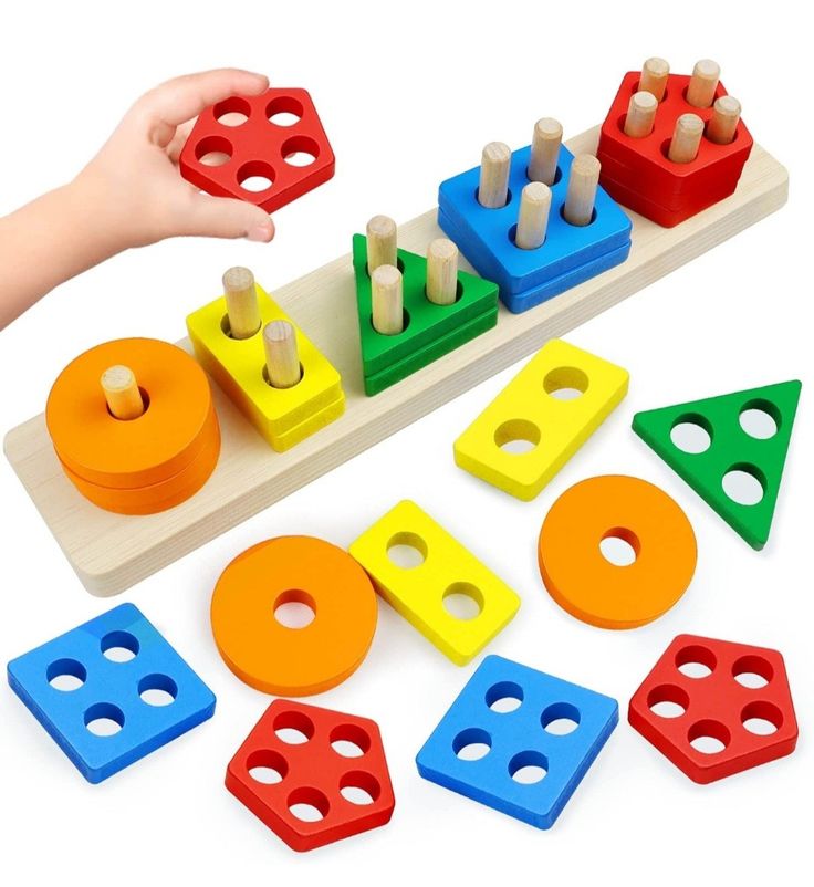 a child's hand is playing with wooden toys