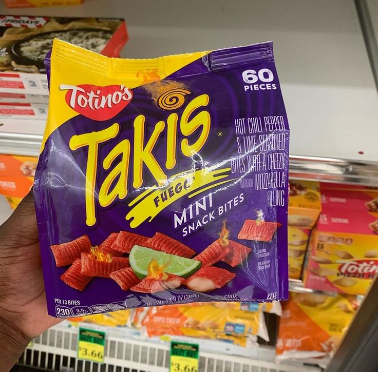 a person holding up a bag of taks in a store