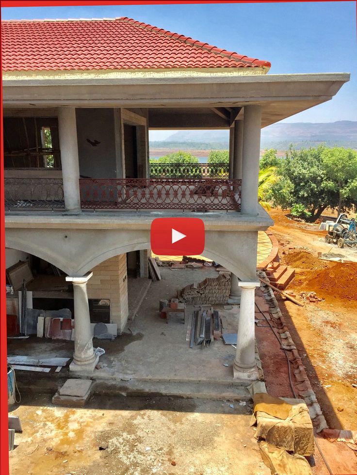 an aerial view of a house being built with red tile on the roof and balcony