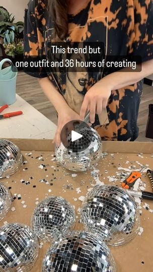 a woman is cutting into some disco balls