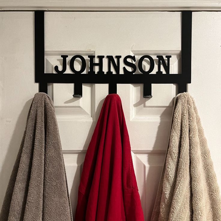 two towels hanging on a hook in front of a door with the name johnson written on it