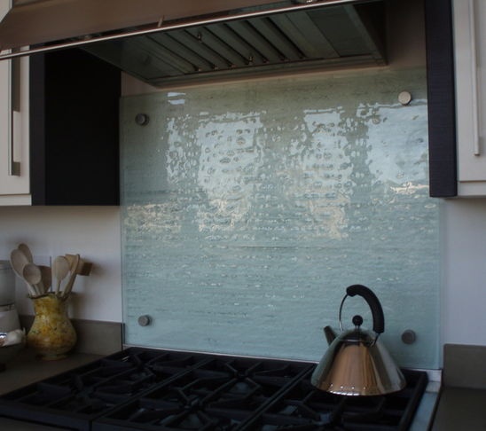 a tea kettle sitting on top of a stove next to a wall mounted oven hood