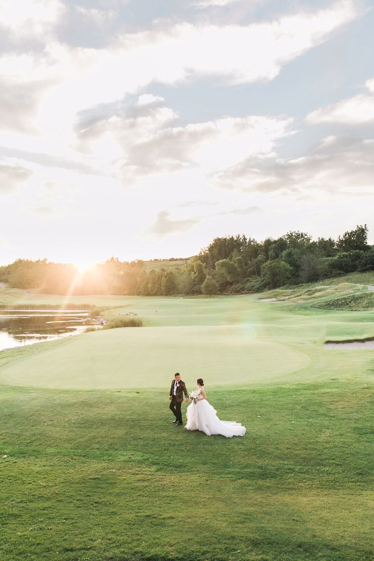 a bride and groom walking on the golf course