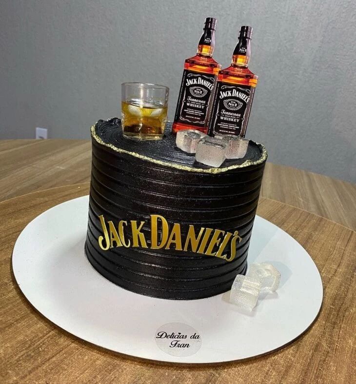 there is a cake that has two bottles on it and ice cubes in the middle