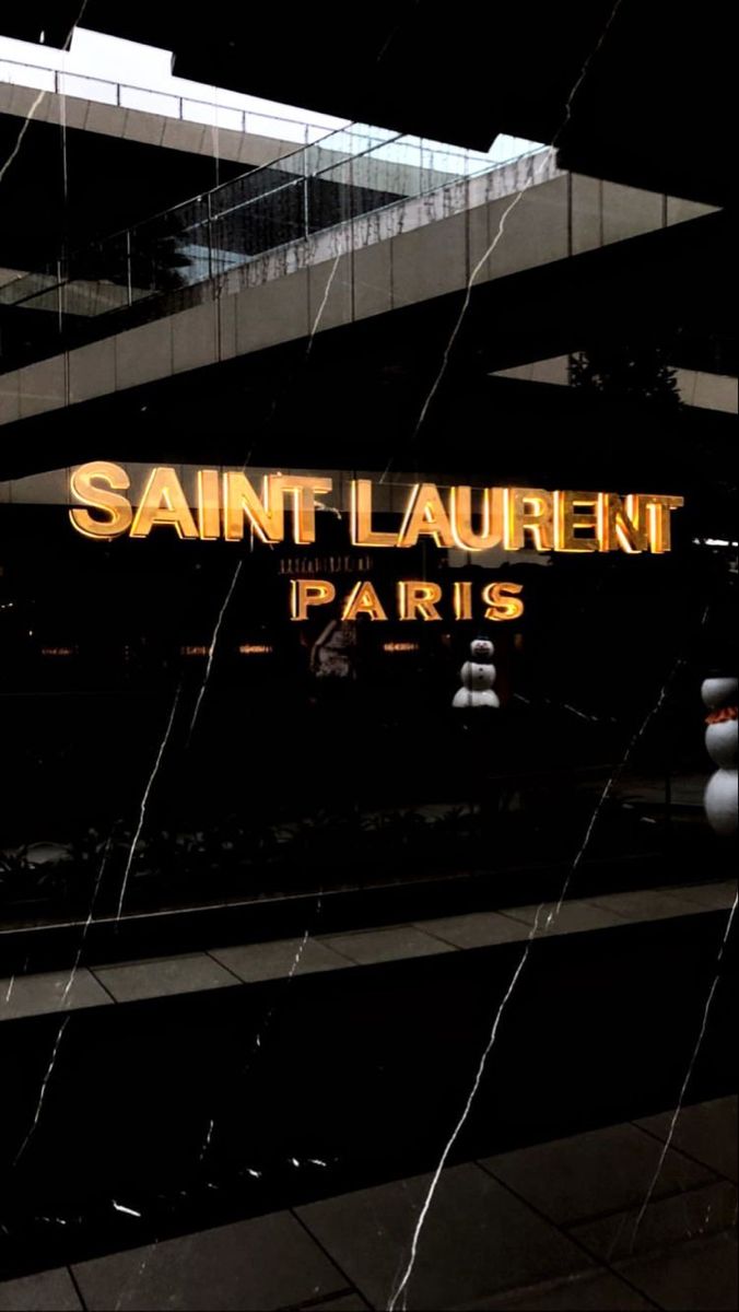 the entrance to saint laurent paris is lit up in gold and black with white marble