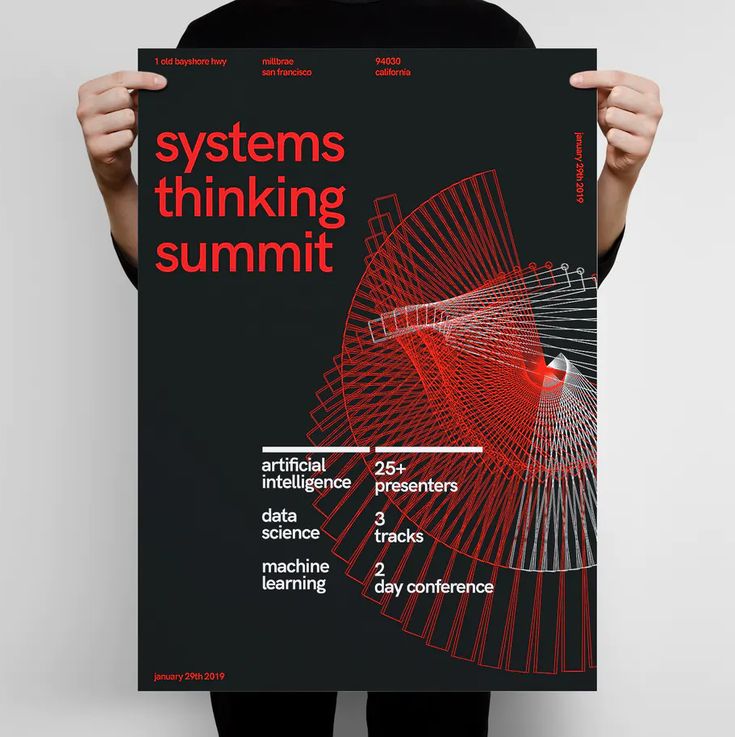 a person holding up a poster with the words systems thinking summit in red on it