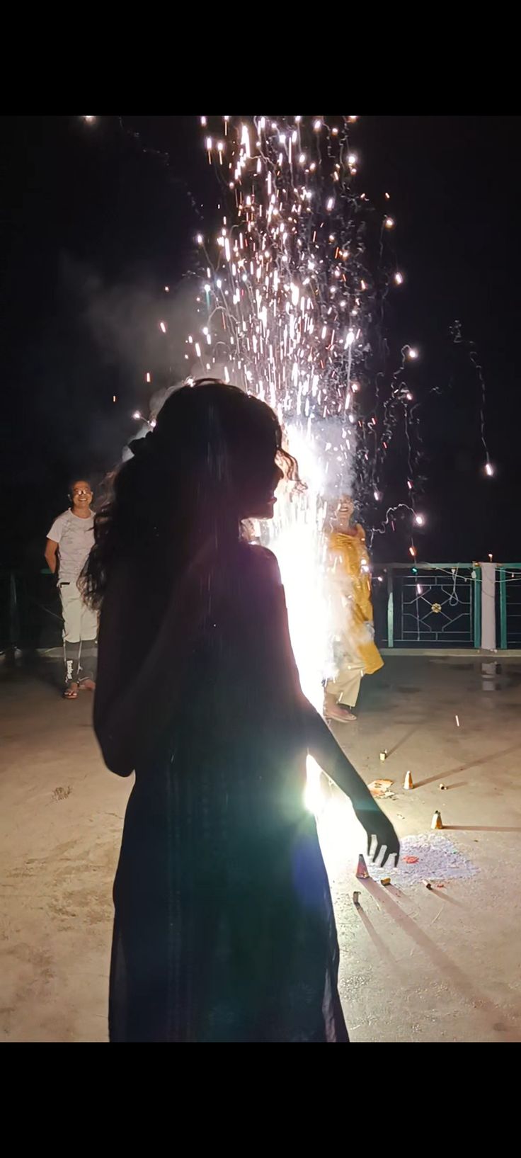 a woman standing in front of a firework display