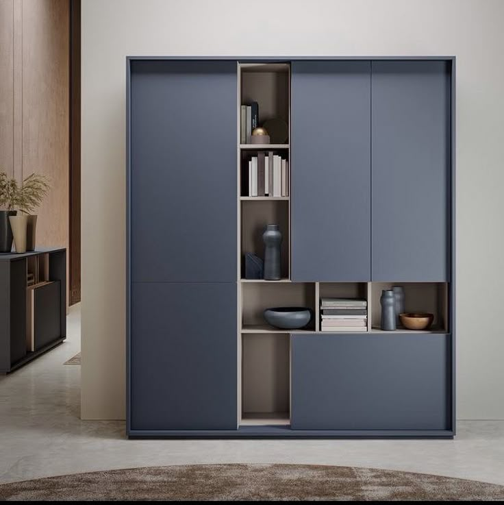 a blue cabinet with books and vases on it