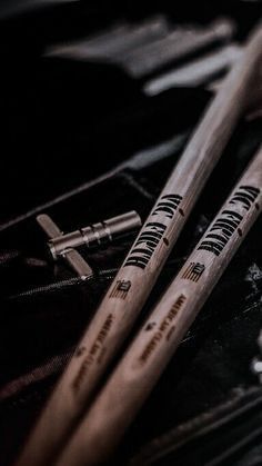 two drumsticks sitting next to each other on a black bag with zippered pouch