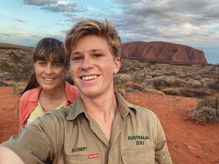 two people taking a selfie in front of the ayeebah rock formation, australia