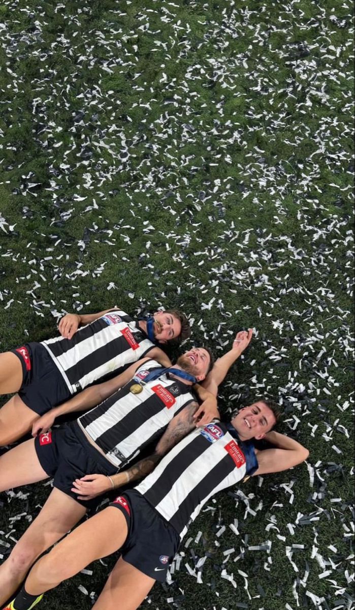 three women laying on the ground with their arms around each other