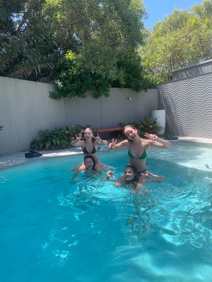 three women are in the pool posing for a photo